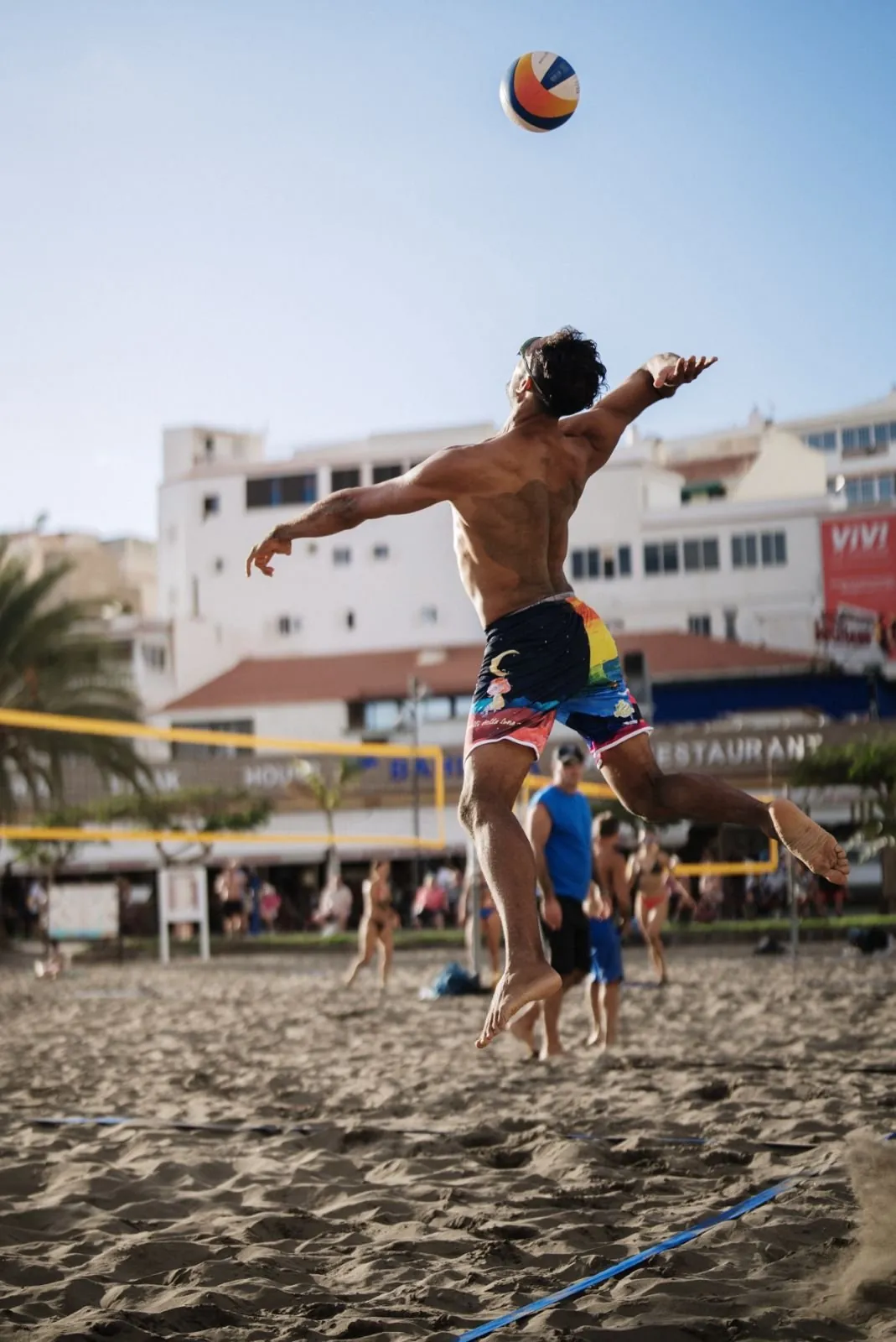 Salto y remate durante un partido de vóley playa
